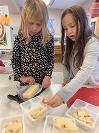 Two students putting together packaged meals