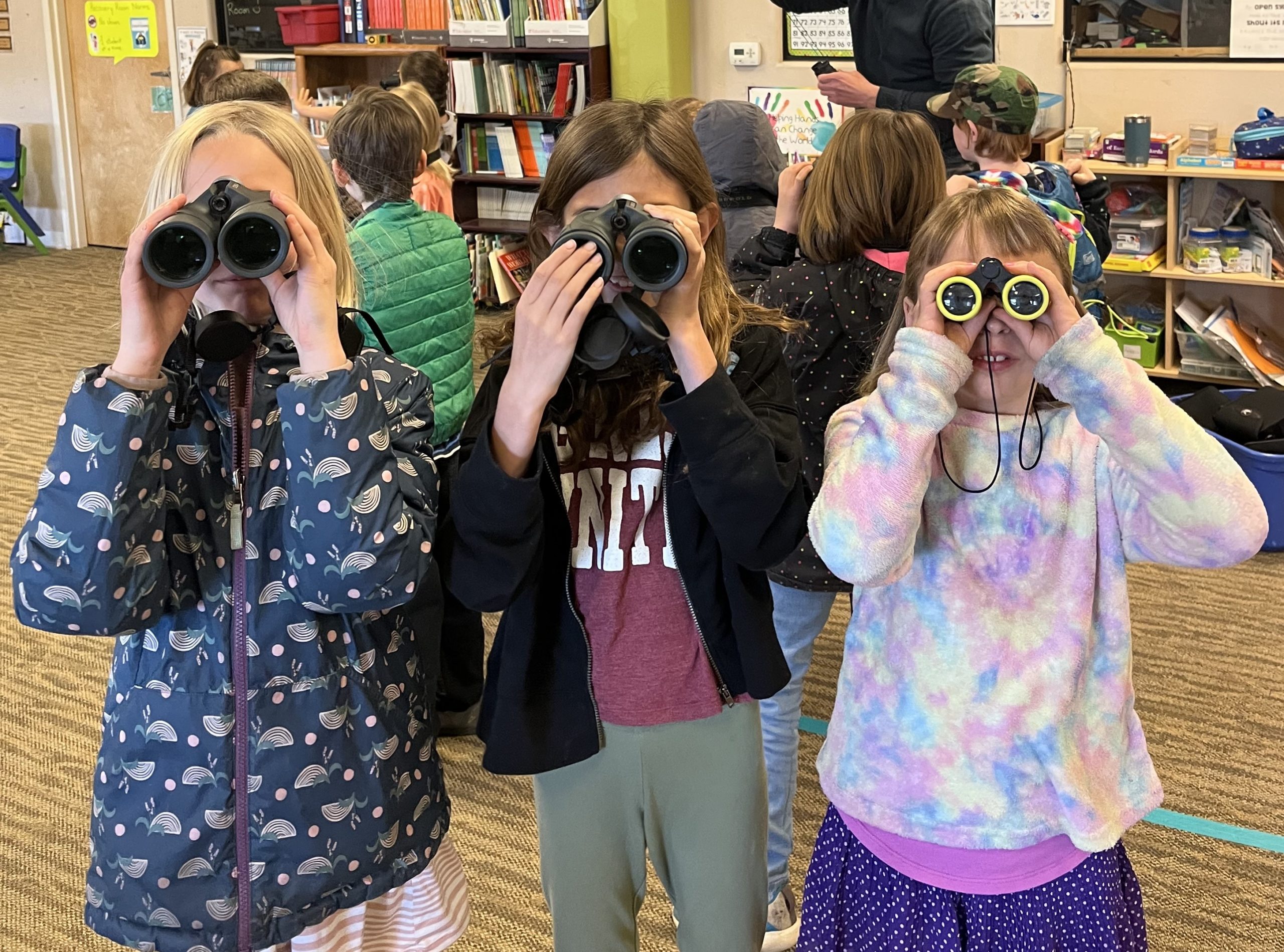 Three PPOS students lined up looking through binoculars.