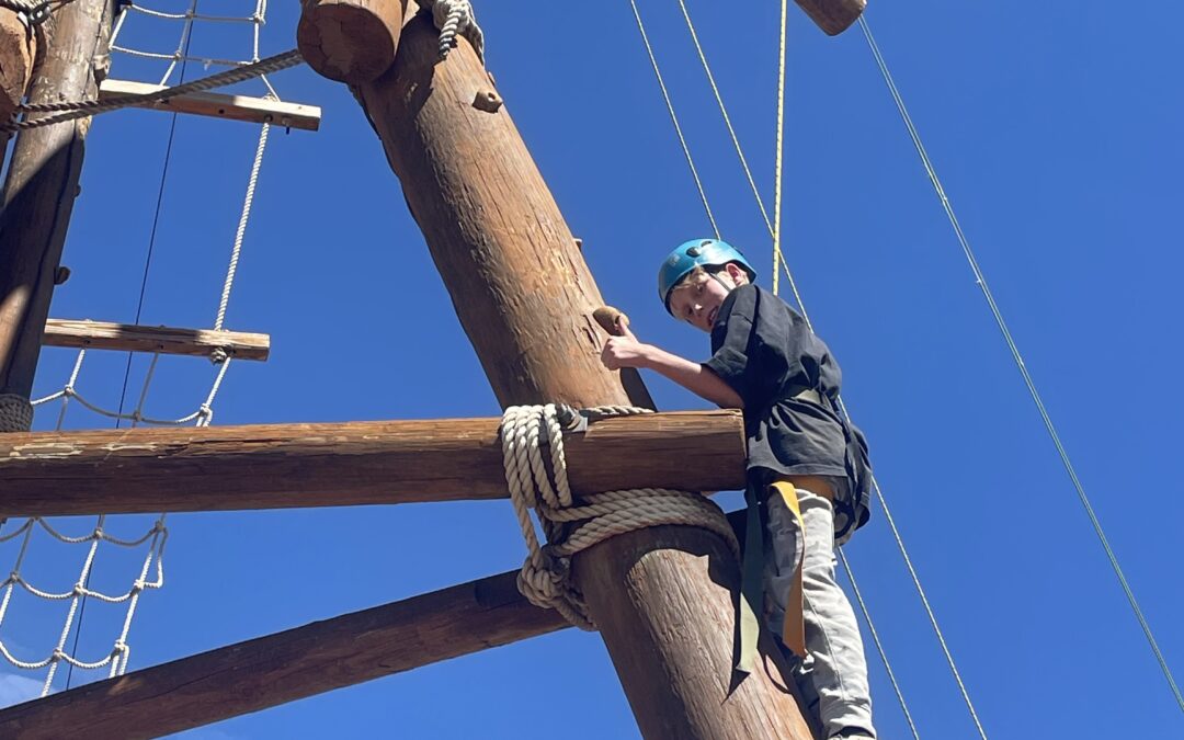 PPOS Student climbing a pole at the High Endeavors Challenge Course