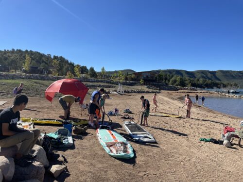 PPOS Students inflating paddle boards on the shore of Lake Nighthorse.