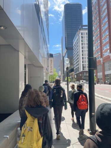 A group of PPOS students walking on a sidewalk in downtown Denver