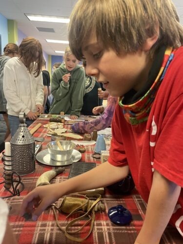 Fifth-grader Jay looks through the historical artifacts brought to the school by the Sons of the Revolution.