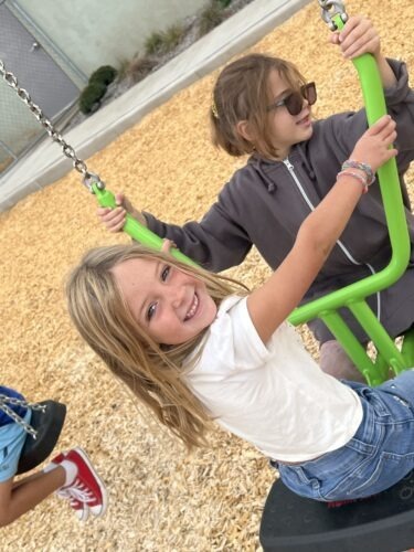 Two PPOS students playing on the swings.
