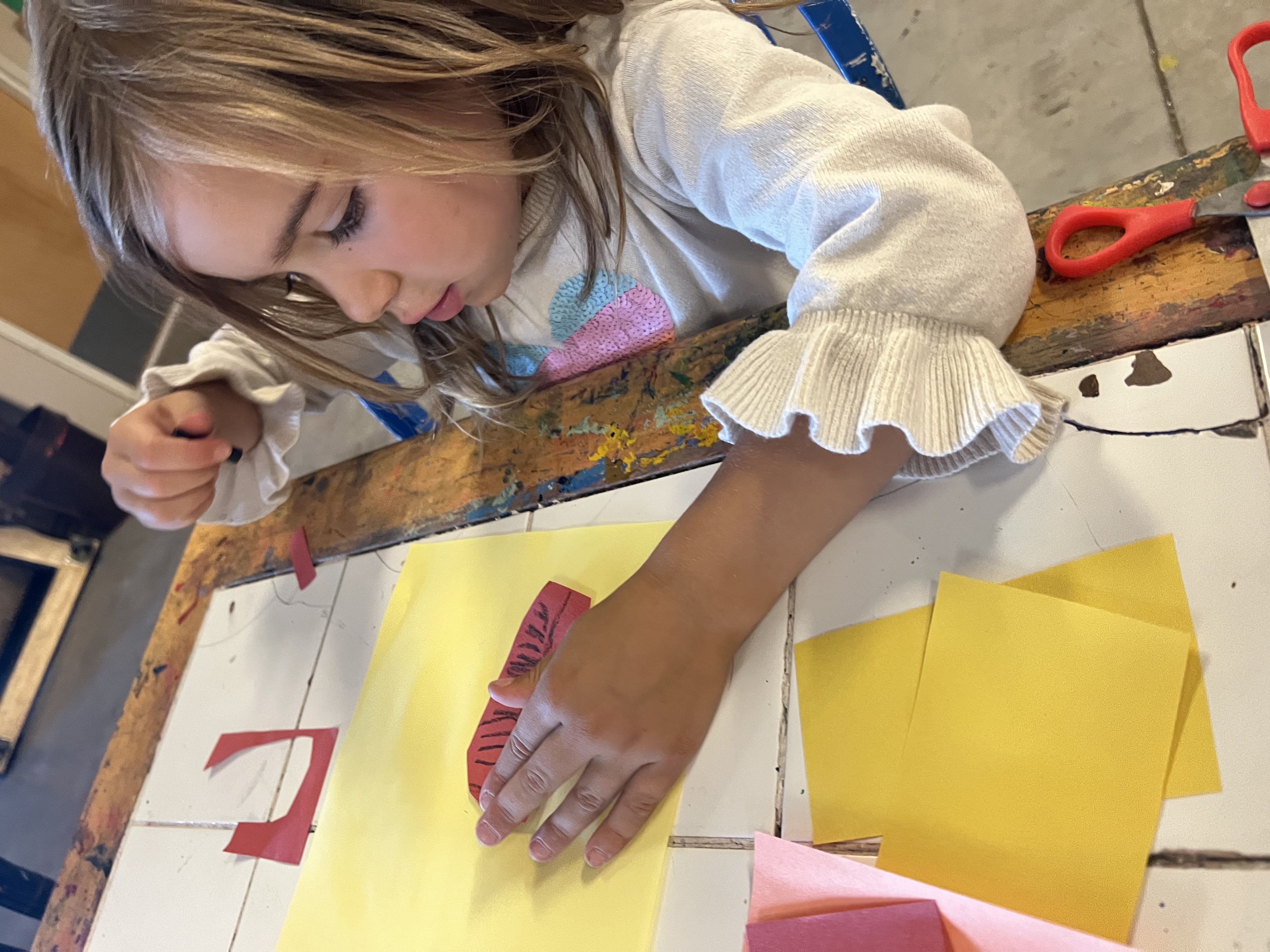 A PPOS student working on an art project with construction paper.