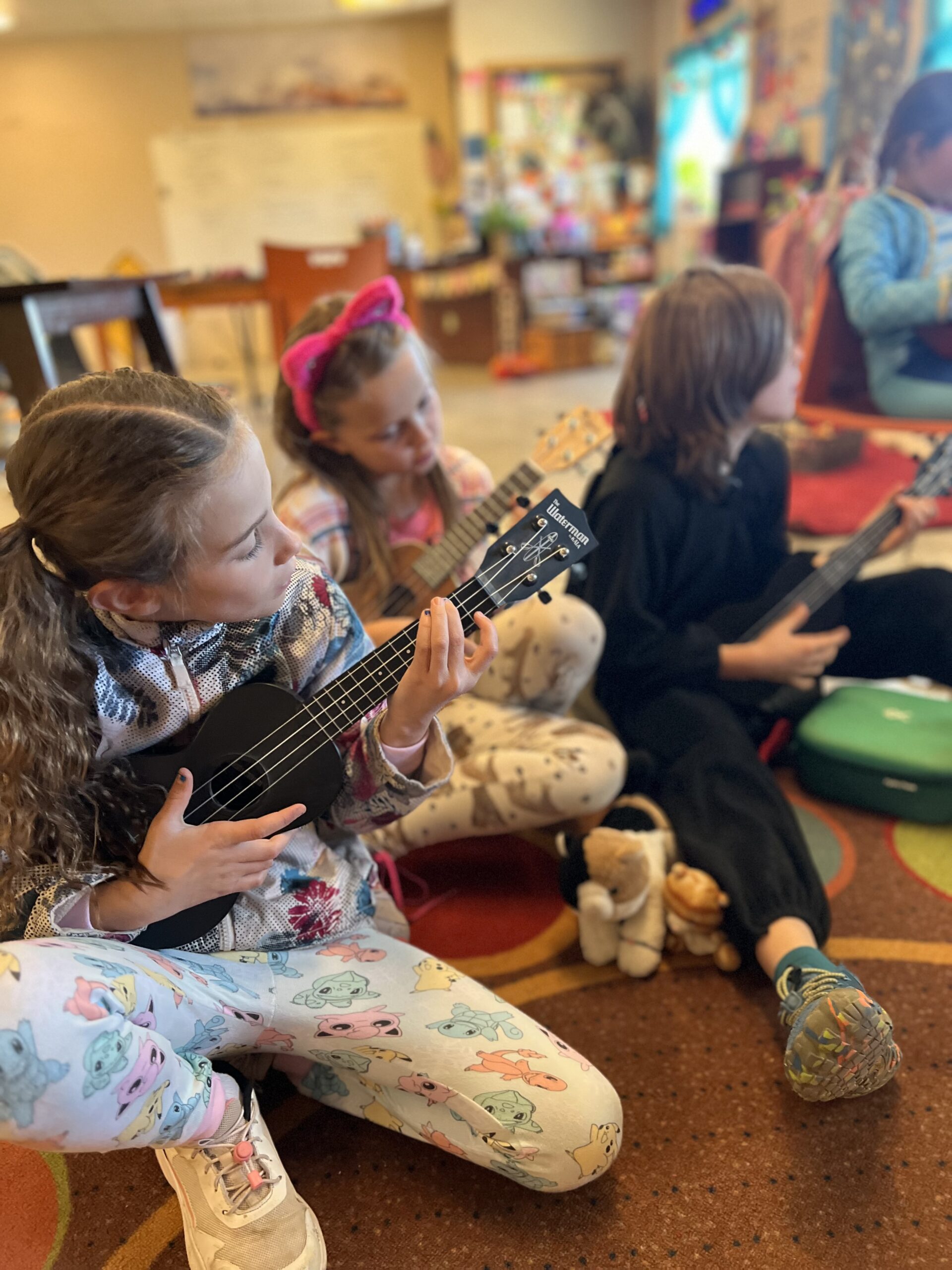 Three POS Students playing music on ukuleles.