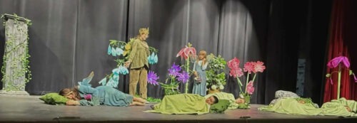 Four PPOS students on stage in costume for a scene from a Midsummers Night Dream.