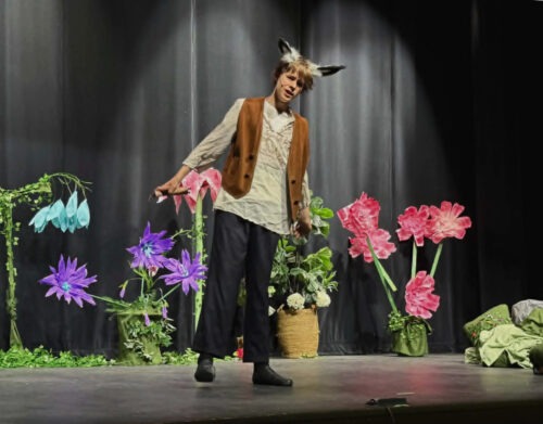 A PPOS student on stage in costume for a scene from a Midsummers Night Dream.