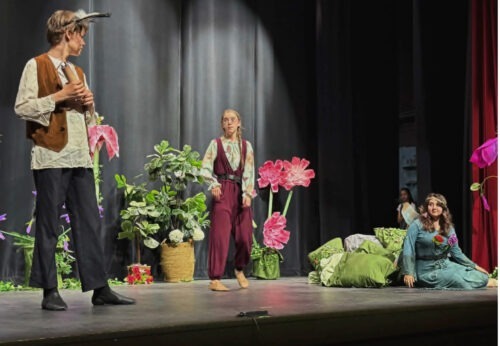 Three PPOS students on stage in costume for a scene from a Midsummers Night Dream.