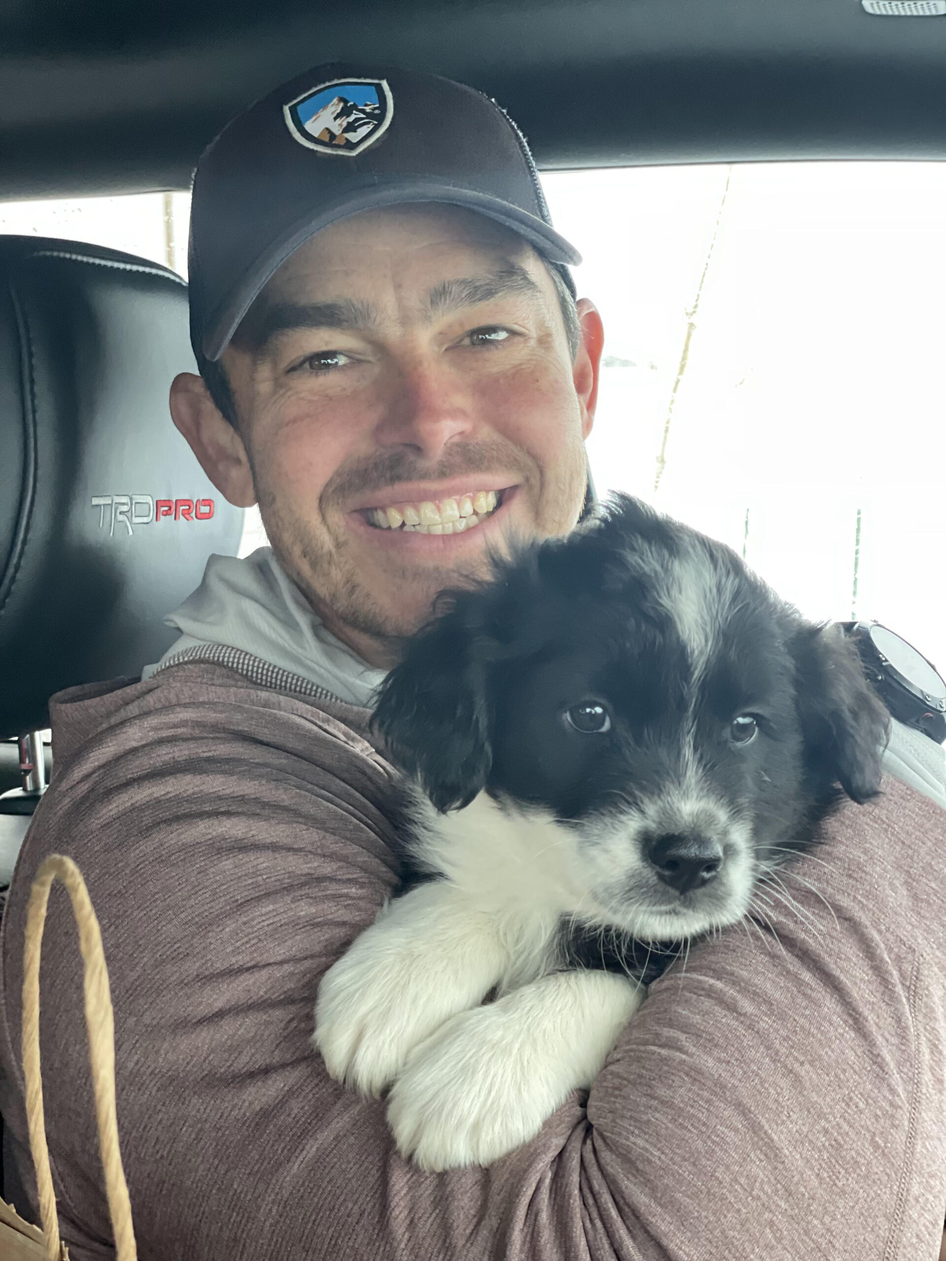 Close up of Steve in car holding puppy